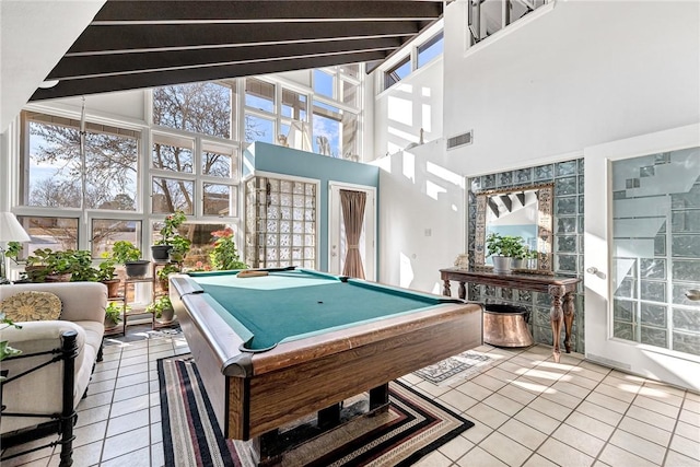 game room with tile patterned floors, pool table, and a towering ceiling