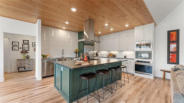 kitchen with appliances with stainless steel finishes, wood ceiling, island range hood, and white cabinetry