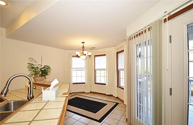 dining space featuring a notable chandelier, light tile patterned floors, plenty of natural light, and sink