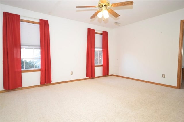 carpeted spare room with ceiling fan