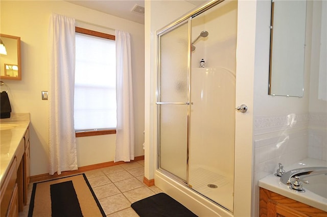 bathroom featuring walk in shower, vanity, and tile patterned flooring