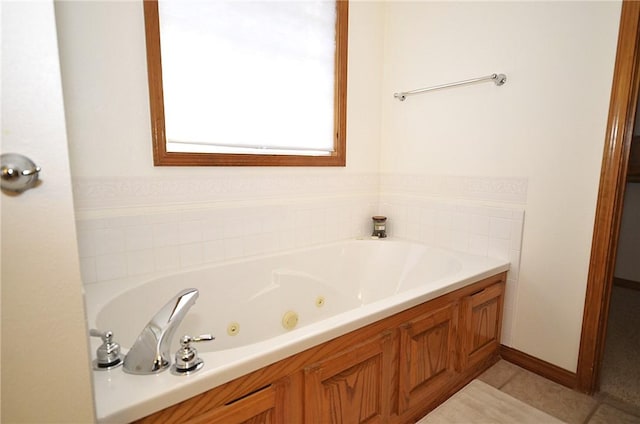 bathroom with a tub to relax in and tile patterned floors