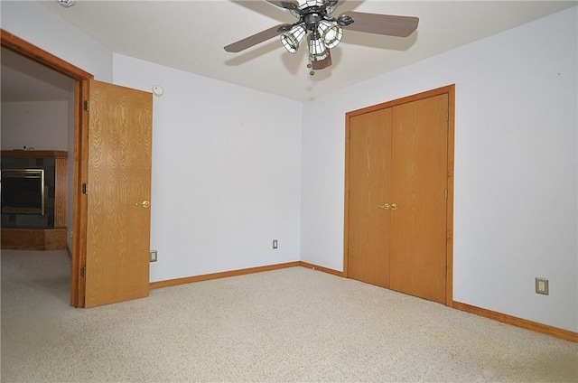 unfurnished bedroom with ceiling fan, carpet, and a closet