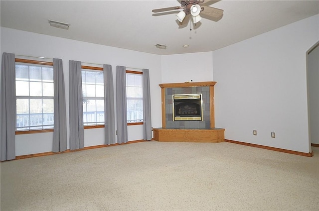 unfurnished living room featuring ceiling fan, carpet flooring, and a fireplace