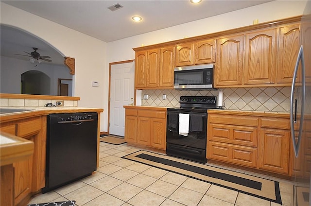 kitchen with ceiling fan, tile counters, backsplash, light tile patterned flooring, and black appliances