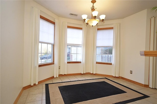 interior space with light tile patterned floors and a chandelier