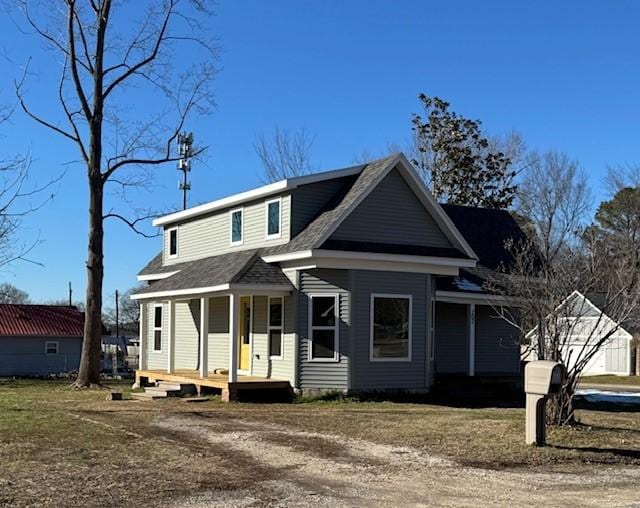 view of front facade with roof with shingles and covered porch