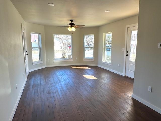 interior space featuring baseboards, dark wood-style flooring, and ceiling fan