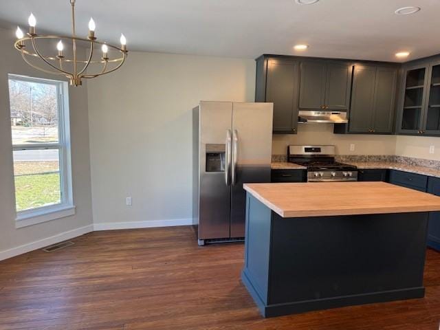 kitchen featuring under cabinet range hood, a wealth of natural light, glass insert cabinets, and appliances with stainless steel finishes