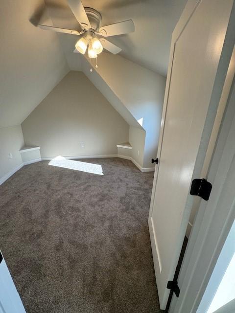 bonus room with lofted ceiling, baseboards, dark colored carpet, and ceiling fan