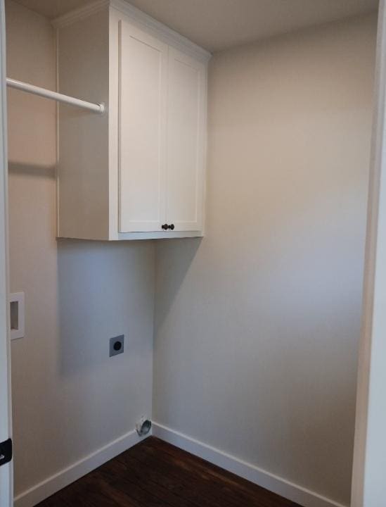 clothes washing area with cabinet space, electric dryer hookup, dark wood-type flooring, and baseboards