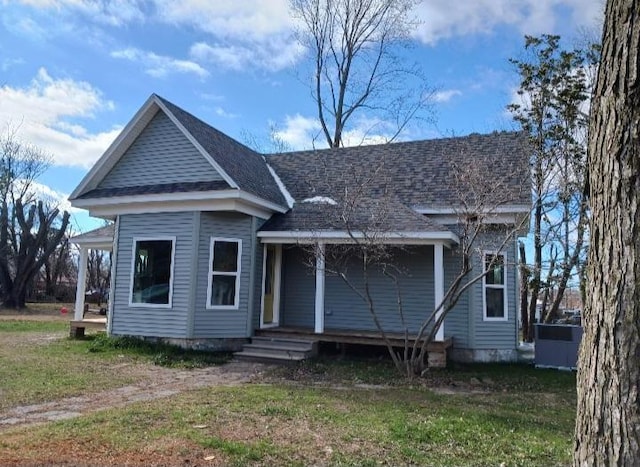 view of front of house with a front lawn and roof with shingles