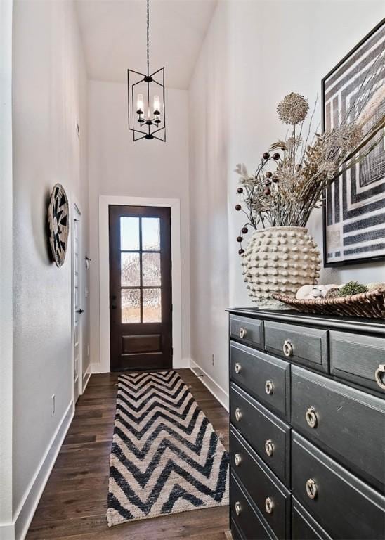 entryway featuring a high ceiling, dark hardwood / wood-style floors, and an inviting chandelier