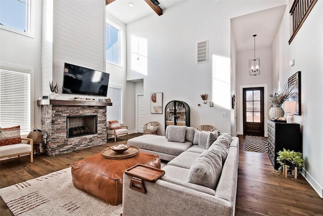 living room with a stone fireplace, dark hardwood / wood-style flooring, and a high ceiling