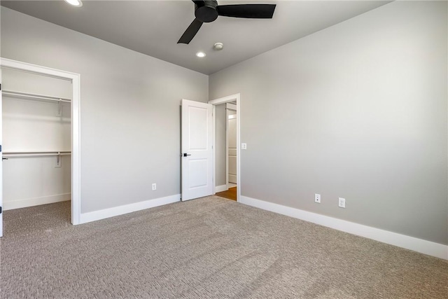 unfurnished bedroom with ceiling fan, a spacious closet, a closet, and carpet flooring