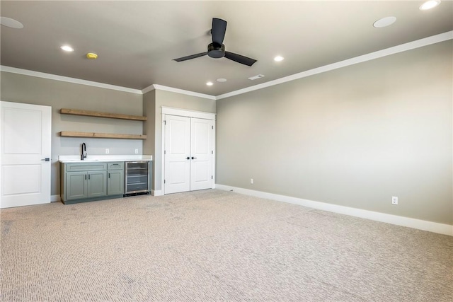 interior space with ceiling fan, light colored carpet, ornamental molding, and wine cooler