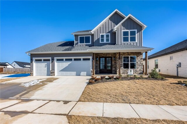 view of front of home with a garage, a porch, and french doors