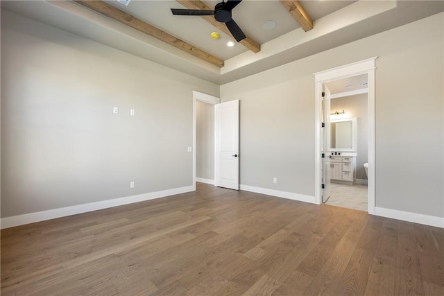 unfurnished bedroom with ensuite bathroom, ceiling fan, a high ceiling, light wood-type flooring, and beam ceiling