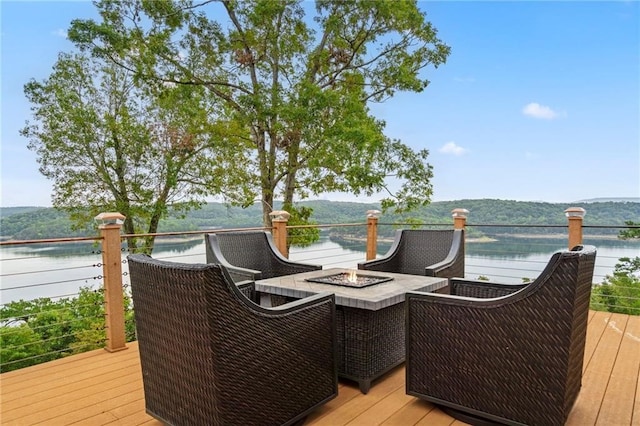 deck with a water view and an outdoor fire pit