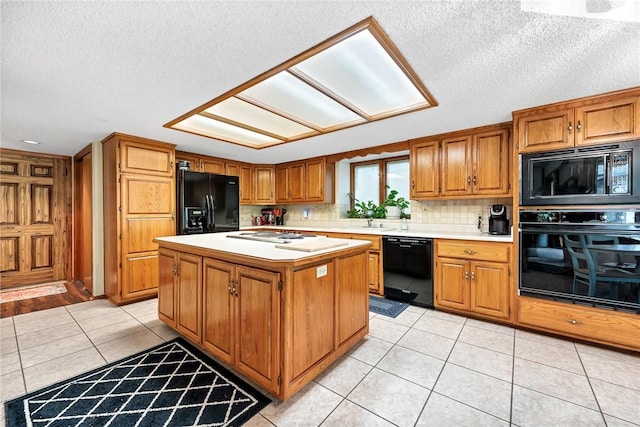 kitchen with light tile patterned floors, tasteful backsplash, black appliances, a textured ceiling, and a kitchen island