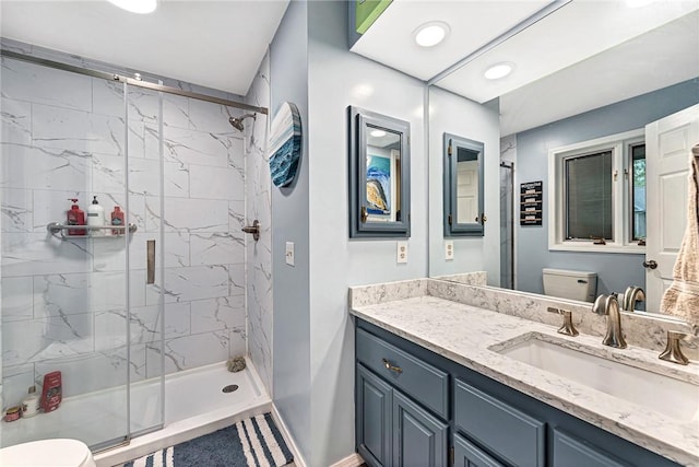 bathroom featuring vanity, a shower with shower door, and toilet