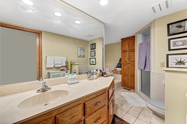 bathroom with tile patterned floors, toilet, a shower with shower door, tile walls, and vanity