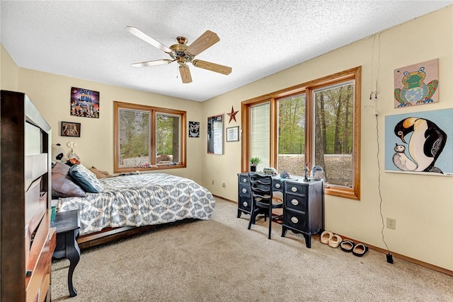 bedroom featuring ceiling fan, a textured ceiling, and carpet