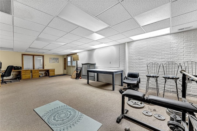 interior space with a paneled ceiling and carpet