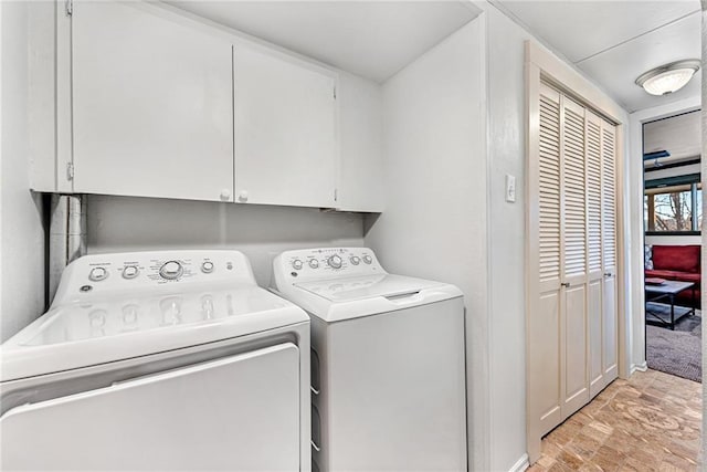 laundry room featuring washer and clothes dryer and cabinets