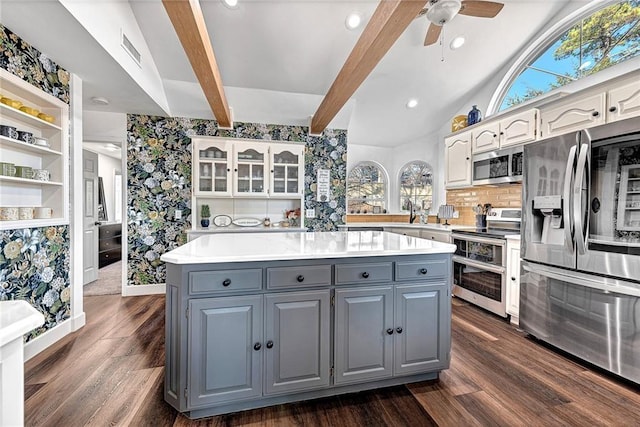 kitchen featuring appliances with stainless steel finishes, white cabinetry, beamed ceiling, decorative backsplash, and gray cabinetry