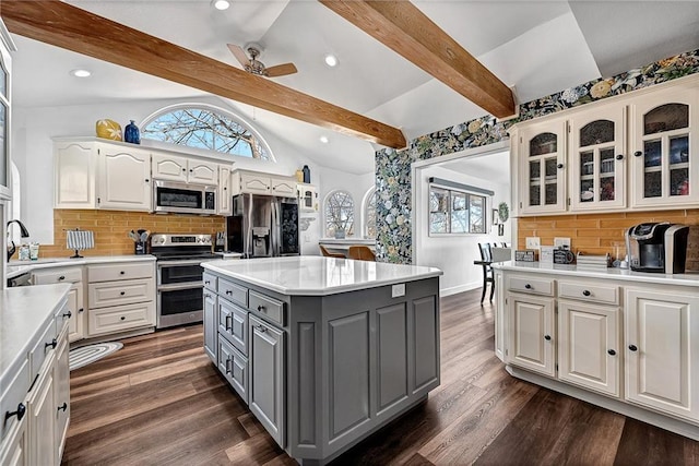 kitchen featuring white cabinetry, decorative backsplash, stainless steel appliances, and a kitchen island