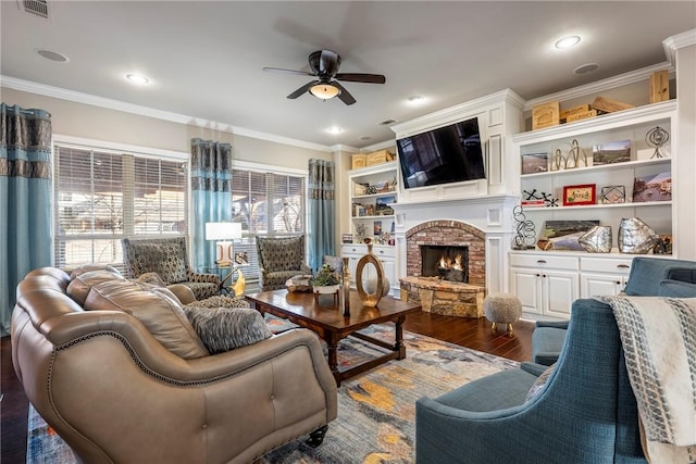 living room featuring ceiling fan, dark wood-type flooring, ornamental molding, and a fireplace