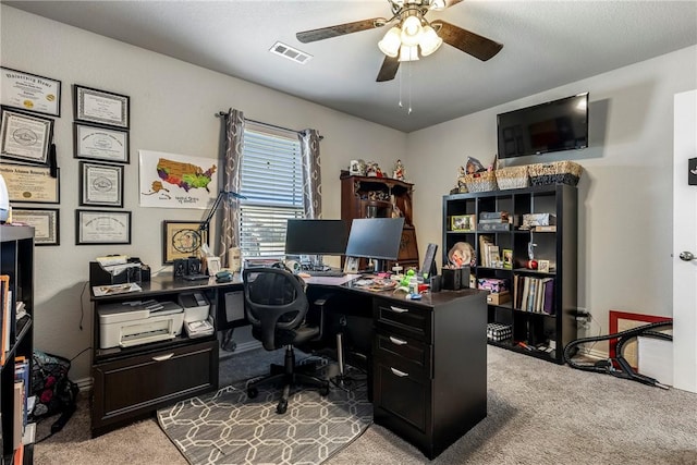 carpeted home office featuring ceiling fan