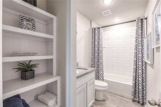 1412 NW 5th Ave, Highfill, AR 72734 - full bathroom with visible vents, toilet, shower / bath combo, vanity, and wood finished floors