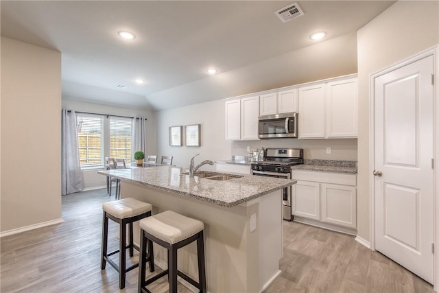 1412 NW 5th Ave, Highfill, AR 72734 - kitchen featuring appliances with stainless steel finishes, white cabinets, a center island with sink, and a sink
