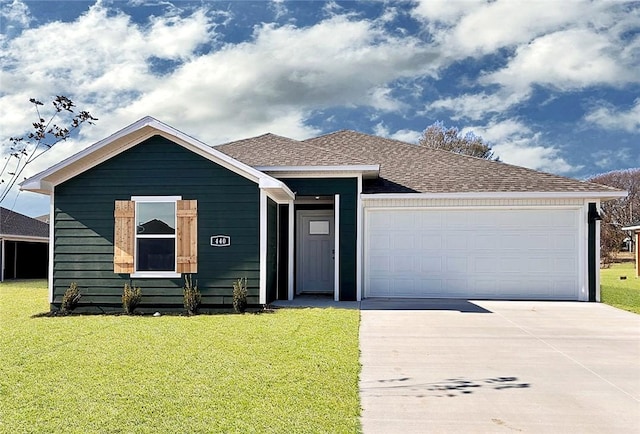 ranch-style house featuring a garage, driveway, a shingled roof, and a front lawn