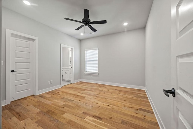 unfurnished bedroom featuring ceiling fan, light hardwood / wood-style floors, and connected bathroom