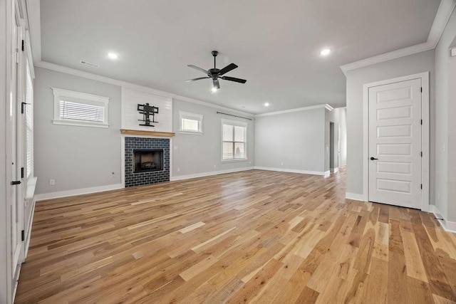 unfurnished living room featuring ceiling fan, a fireplace, ornamental molding, and light hardwood / wood-style flooring