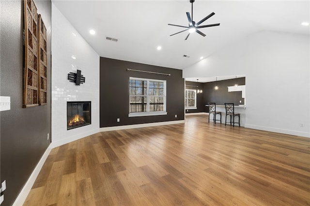 29 Shanklin Dr, Bella Vista, AR 72715 - unfurnished living room featuring a ceiling fan, a large fireplace, wood finished floors, high vaulted ceiling, and recessed lighting