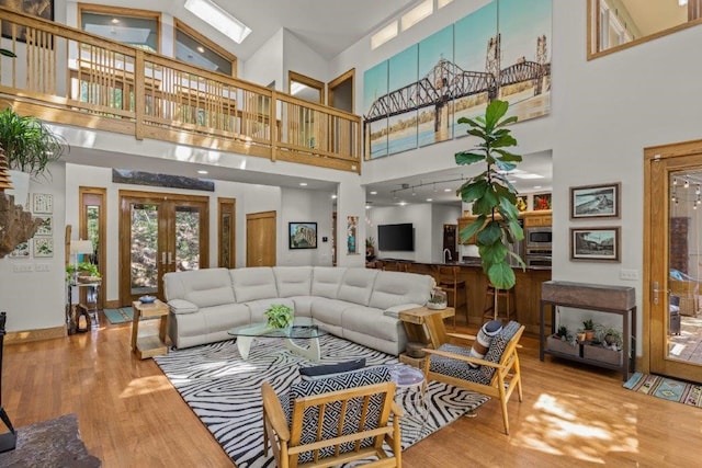 interior space with wood-type flooring, french doors, and high vaulted ceiling