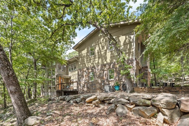 view of property exterior with a wooden deck and central AC unit