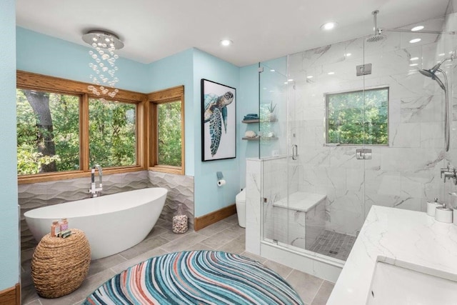 bathroom with tile patterned floors, vanity, and shower with separate bathtub