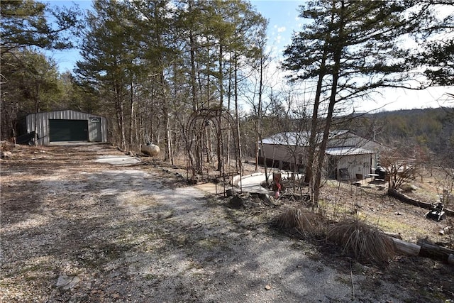 view of yard featuring a garage and an outbuilding