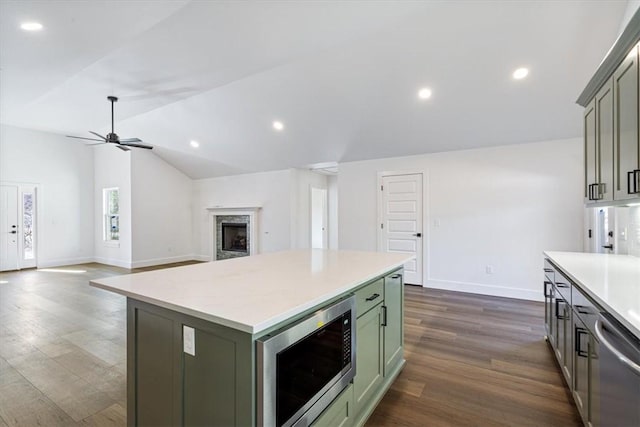 kitchen featuring lofted ceiling, a kitchen island, stainless steel appliances, green cabinetry, and ceiling fan