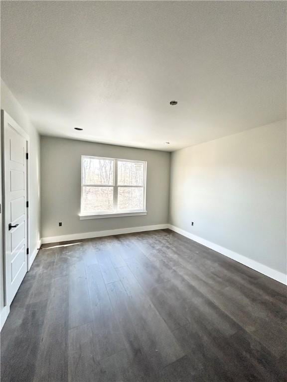 spare room with dark hardwood / wood-style flooring