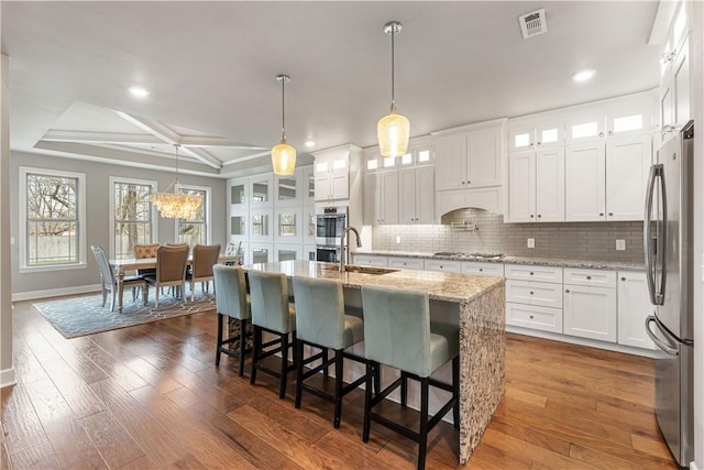 kitchen featuring a center island with sink, sink, coffered ceiling, white cabinetry, and stainless steel appliances