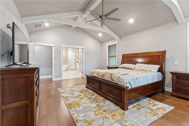 bedroom with ceiling fan, vaulted ceiling with beams, ensuite bathroom, and light hardwood / wood-style floors