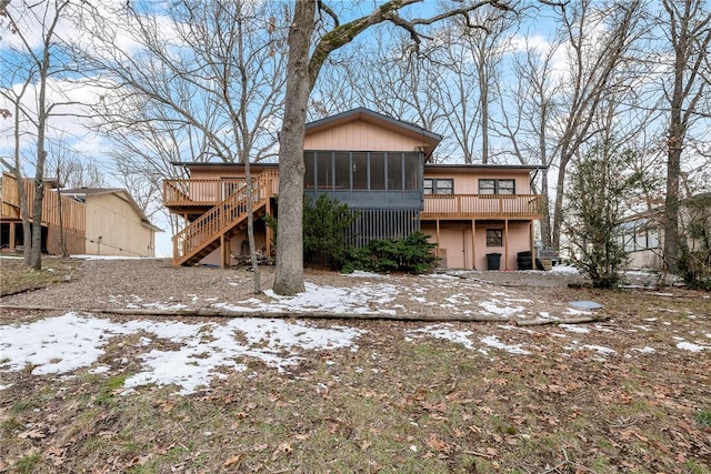 snow covered property featuring a deck and a sunroom