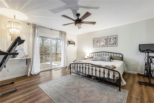 bedroom with dark wood-type flooring, access to exterior, and ceiling fan with notable chandelier