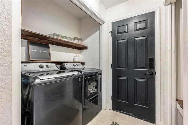 washroom with light tile patterned floors and washing machine and dryer